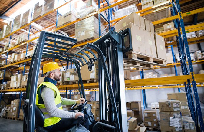 forklift-operator-stocking-shelves-in-warehouse